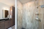 The primary bedroom features a walk-in custom tile shower.